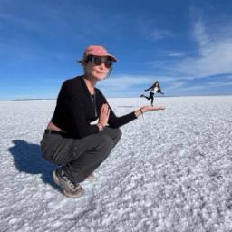 Female holding a figure in the palm of her hand perspective photo on the Uyuni Salt Flat