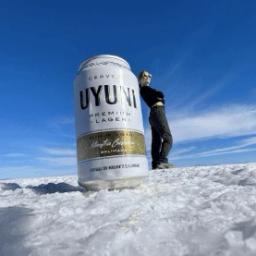 Female leaning against a beer can perspective photo on the Uyuni Salt Flat