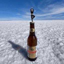 Female in the yoga pose atop a beer bottle perspective photo on the Uyuni Salt Flat